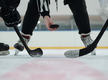 Hockey players holding hockey sticks on ice