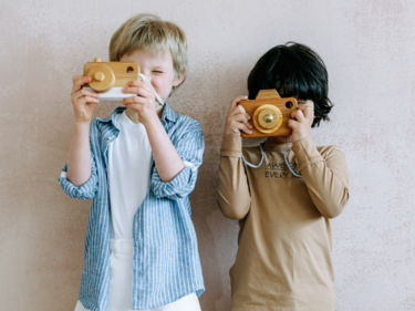 two students each holding up a wooden camera