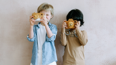 two students each holding up a wooden camera