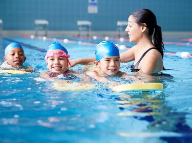 children swimming with an instructor