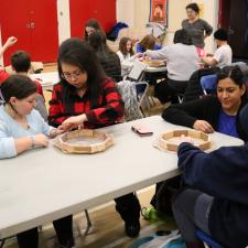 Two female parents support their grade 5 students with their hand drum